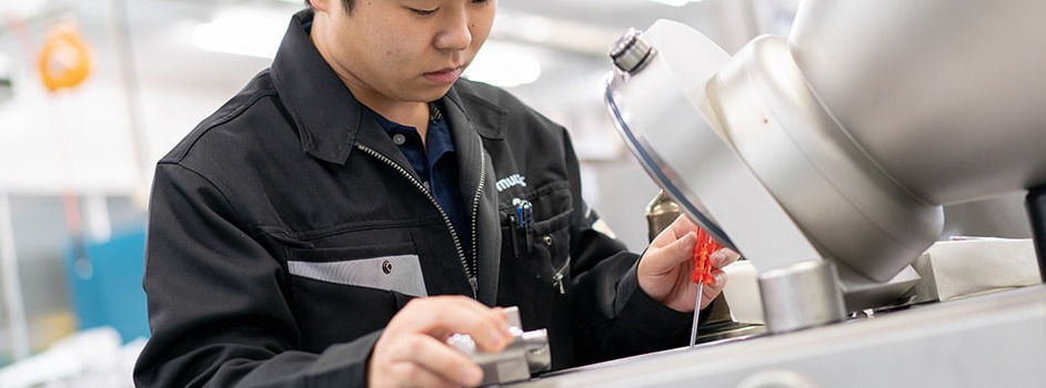 包装機の部品を整備するサービスエンジニア